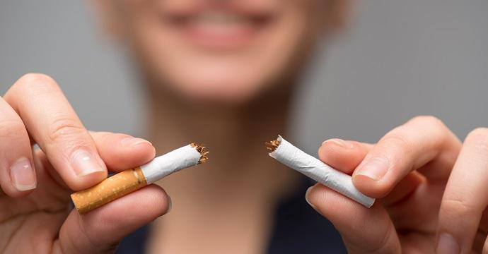 una donna che spezza una sigaretta per la giornata mondiale senza tabacco