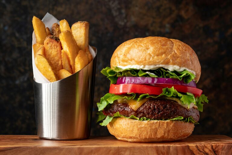 Un tipico piatto di un fast food che è un hamburger con patatine fritte