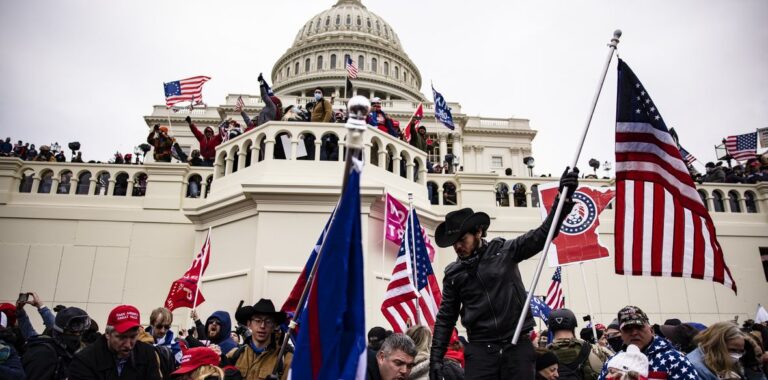 Assalto a Capitol Hill folla con bandiere americane e sullo sfondo il campidoglio